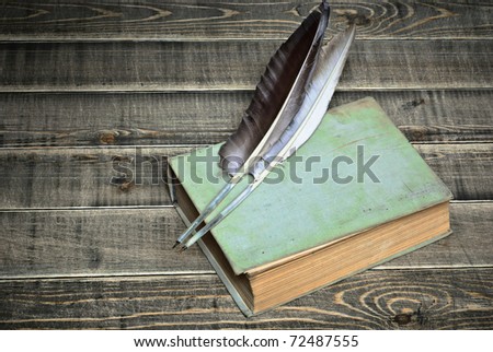 old book and feathers a on table