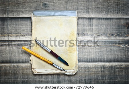 old notebook and pens on a wooden table