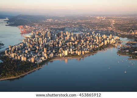 Aerial view of Stanley Park and Downtown Vancouver, BC, Canada. During a hazy sunny sunset.