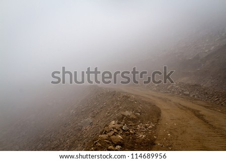 Himalayas. Gravel mountain road in the fog.