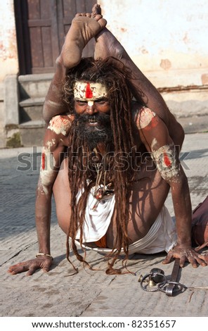 KATHMANDU, NEPAL - OCTOBER 27 : Shiva sadhu (holy man) makes different postures in the yard of the temple Pashupatinath on October 27, 2010 in Kathmandu valley, Nepal.