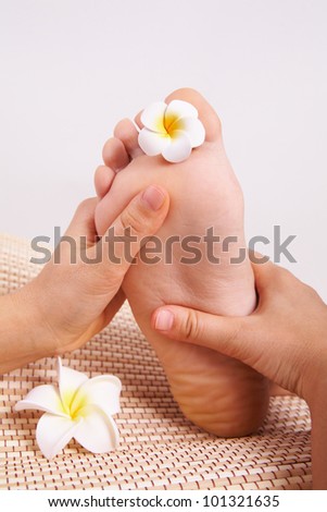 Image of massagist hands doing thai massage foot