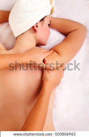 Professional doing massage on female shoulder in spa treatment