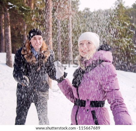 Happy couple playing with snow