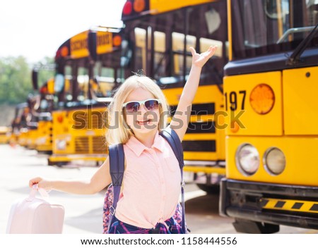 Cheerful girl with her hands up showing her excitement to go first time to school.