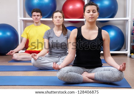 Group  of people sitting in pose lotus yoga on mates in gym