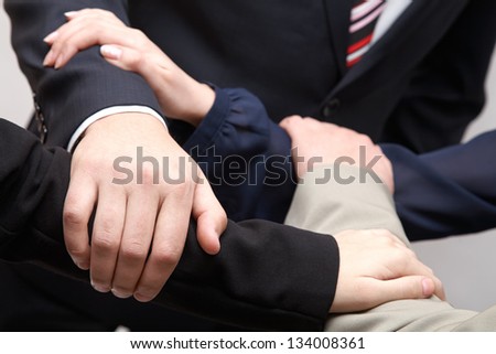 A team of businesspeople hold their hands together