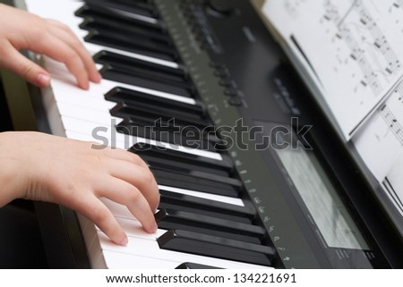 Musical education: childish hands play on piano