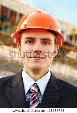 Smiling businessman in helmet while building
