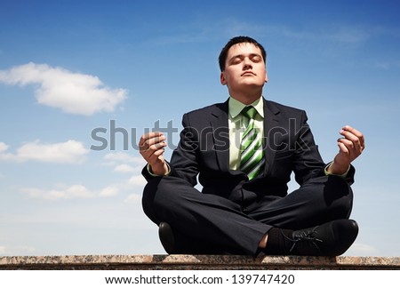 Handsome businessman in suit doing yoga