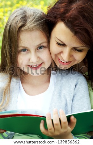 Happy daughter and mother reading book Ã?Â¢?? education outdoor