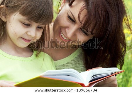 Happy mother teaching to read her small girlÃ?Â¢?? education time