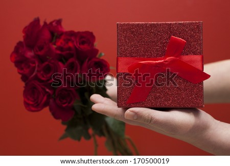 male hands holding rose and present box -love concept