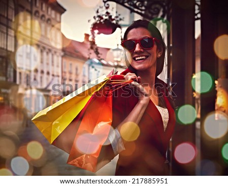 Style smiling girl with shopping bags near the store