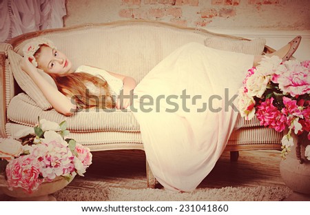 Beautiful teenager girl lying on sofa near flowers