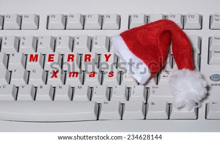 Close up of white keyboard with santa claus hat and text merry xmas