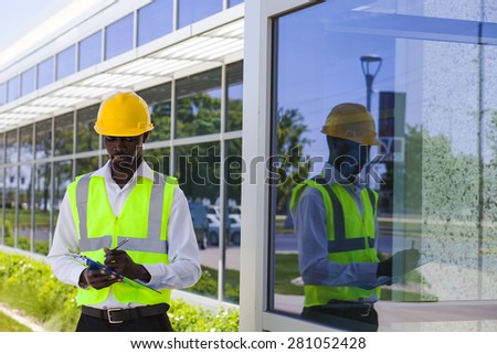 Worker inspector  in helmet checking  modern building