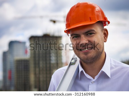 Happy worker architect showing success thumb up on the background of construction