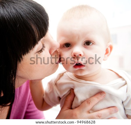 Lovely mother kissing her son - family portraits
