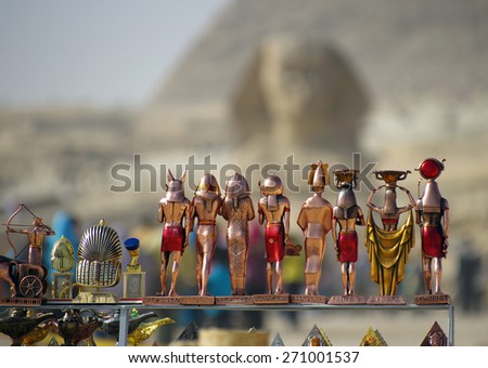 Souvenir figures of the Egyptian gods and pharaohs on background of Sphinx and pyramids. Closeup.