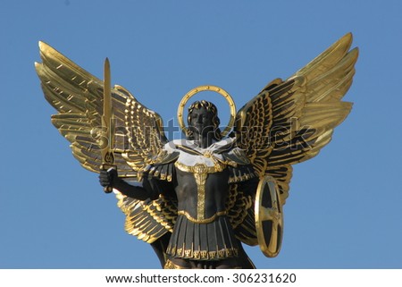 Archangel Michael Sculpture at Independence Square (Maidan Nezalezhnosti, Khreschatyk), Kiev, Ukraine. Gold plated bronze statue  isolated against a blue sky.