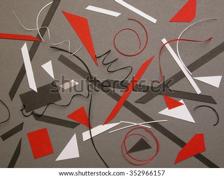 Abstract composition from scraps of paper - red, black , white on a gray background . Lines, squares, circles, triangles.
