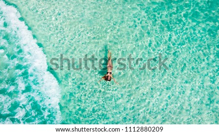 Young woman floating in the clear sea of the Mexican Caribbean. Cancun, Mexico.