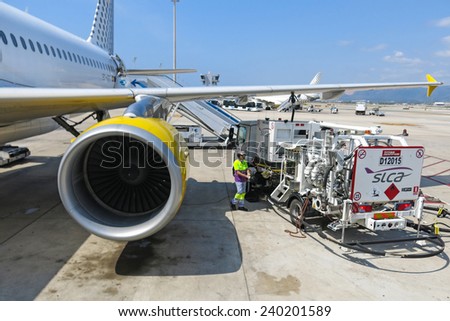 BARCELONA- AUGUST 5: Airbus A320 of the Vueling Airlines receiving fuel from tanker truck at Barcelona International Airport on August 5, 2014 in Barcelona, Catalonia, Spain.