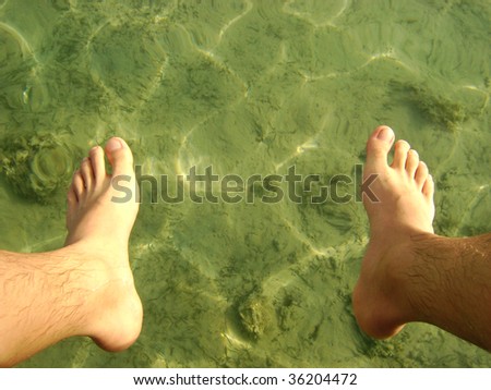 Relaxed male foots on vacation by the sea