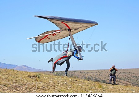 CRIMEA UKRAINE SEPTEMBER 4 Competitor of the Grininko hang gliding competitions takes part in the Klementieva mountain on September 4 2012 in Crimea Ukraine CRIMEA UKRAINE SEPTEMBER 4 Competitor of the Grininko hang gliding competitions takes part in the Klementieva mountain on September 4 2012 in Crimea Ukraine