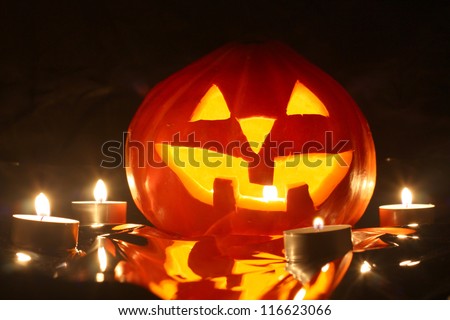 halloween pumpkin jack-o-lantern candle lit, isolated on black background