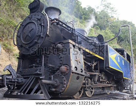 NILGIRI, INDIA - JANUARY 12: Old steam engine on January 12, 2013 in Nilgiri mountains, India. Nilgiri Mountain Railway was built in 1908 and still uses original locomotives.
