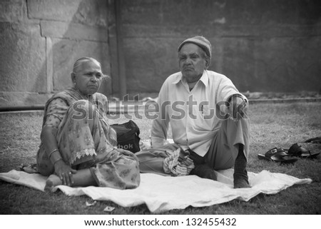 AGRA, INDIA - NOVEMBER 18.  Indian Wife and Husband resting near Agra Fort, during holy festival , November 18 2012.  Agra is the ancient city, attracting Indians from all over the subcontinent.