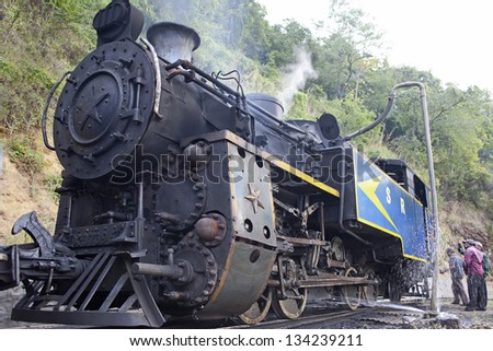 NILGIRI, INDIA - JANUARY 12: Old steam engine on January 12, 2013 in Nilgiri mountains, India. Nilgiri Mountain Railway was built in 1908 and still uses original locomotives.