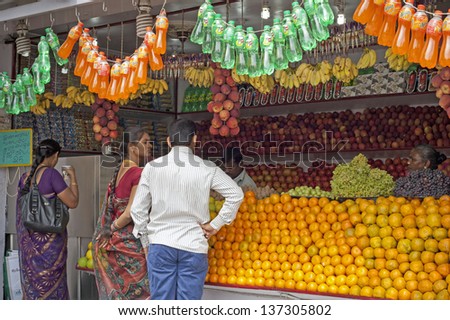 DELHI -  JANUARY 16: Juice stall owner preparing fresh fruit juices on January 16, 2013 in Coimbatore, Tamil Nadu, India. Fresh juices are great alternatives to polluted drinking water in India.