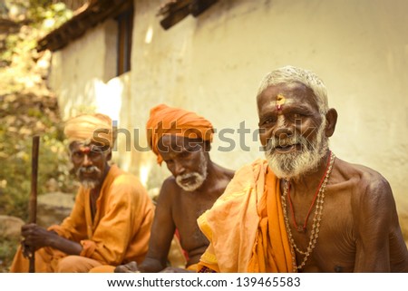 TIRUVANAMALAI, INDIA- JANUARY 15: Holy Sadhu men  in saffron color clothing  blessing in Shiva Temple. January 15, 2013 in India, Tamil Nadu, Tiruvanamalai