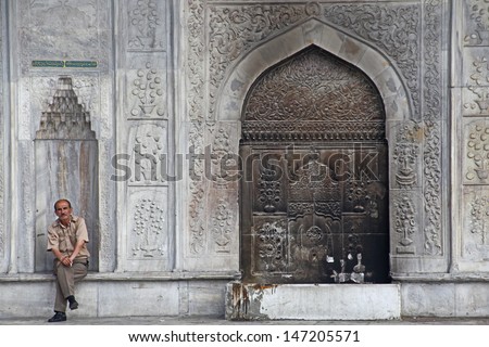 ISTANBUL, TURKEY - JULY 15: Turkish man near Valide Sultan Mosque door on July 15, 2013 in Istanbul, Turkey. Valide Sultan Mosque is most famous as Yeni Cami and was built during 1597-1663 by Ottoman