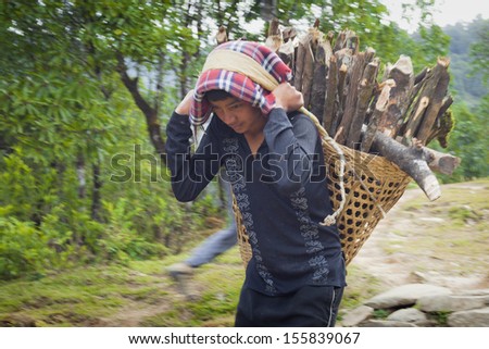 ANNAPURNA AREA, NEPAL - NOVEMBER 13: Several Tibetan women in national clothes with basket on the road on November 13, 2012 in Annapurna District, Nepal.