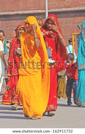 OLD DELHI, INDIA - NOVEMBER 15  - Indian women in colorful saris approach the Red Fort\'s main gate on November 15, 2012, in Delhi, India.
