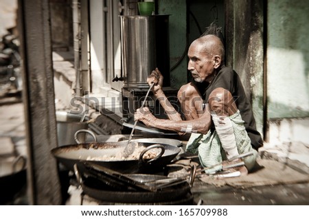VARANASI, INDIA - NOVEMBER 2 - Unidentified man cooks meal for sale in street restaurant in Varanasi, November 2 2013.