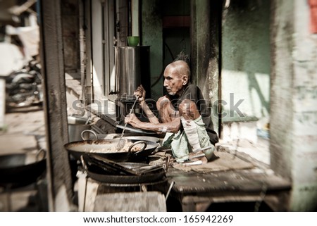 VARANASI, INDIA - NOVEMBER 2 - Unidentified man cooks meal for sale in street restaurant in Varanasi, November 2 2013.