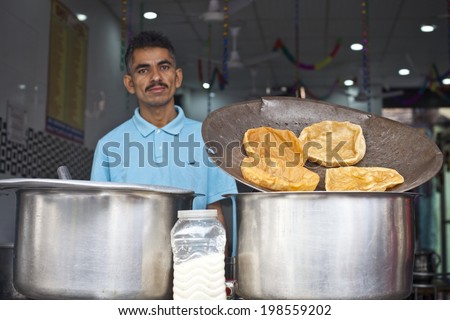 NEW DELHI - NOVEMBER 6: Man cooking and selling India's popular street food - nust and popcorn on November 6, 2013 in New Delhi, India.