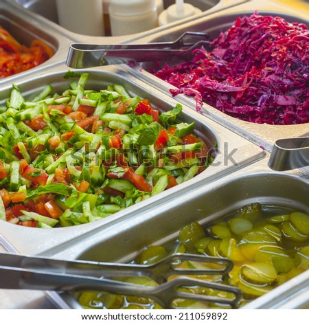 Assortment of fresh vegetable salads and colorful spicy pickles on the traditional food stand selling shawarma sandwiches and other grilled meats in the Old City of Jerusalem (Israel).