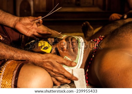 KOCHI, INDIA - DECEMBER 7 , 2012: Unidentified Kathakali exponent preparing for performance by applying face make-up on December 7, 2012 / Kathakali is the classical dance form of Kerala