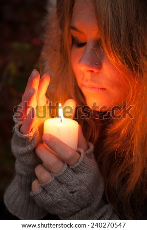 Young woman looking to a candle