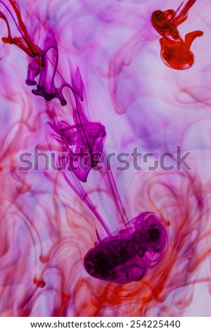 Blue and violet liquid in water making abstract forms