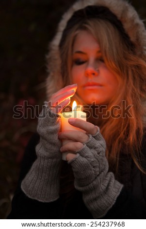 Young woman looking to a candle