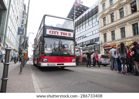 BERLIN, GERMANY - MAY 10, 2015: Bus at Checkpoint Charlie. The crossing point between East and west Berlin became a symbol of the Cold War.
