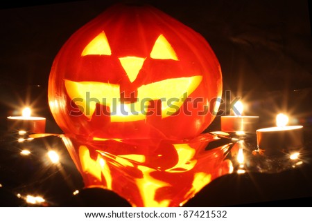 halloween pumpkin jack-o-lantern candle lit, isolated on black background