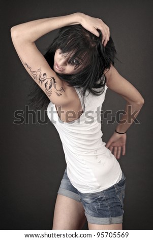 Beauriful model in white clothes with tattoo on her arm